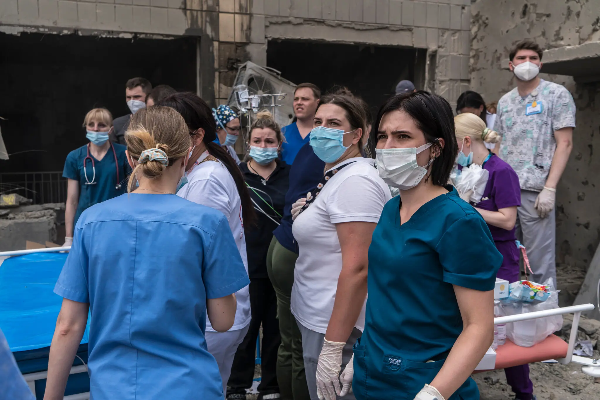 Лікарі та медсестри спостерігають, як рятувальники та волонтери розчищають завали в пошуках тих, хто вижив.